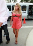 Jessica Simpson show off her breasts in low-cut orange dress